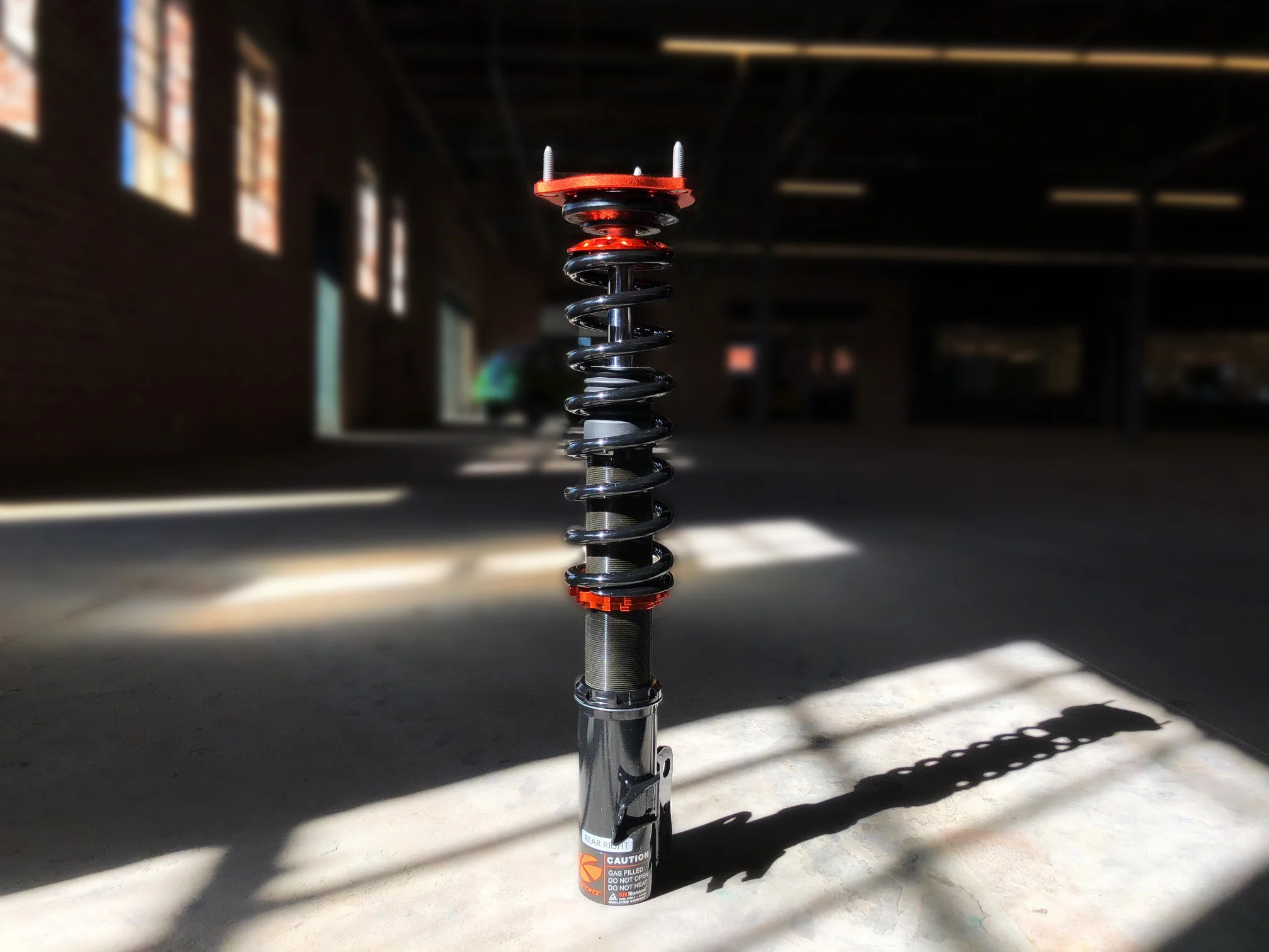 Actual KSport Kontrol Pro coilover photographed in warehouse sunlight